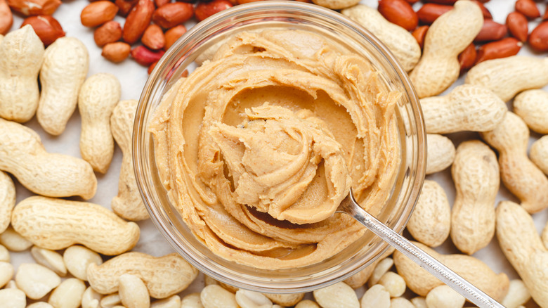 Open container of nut butter with spoon inside