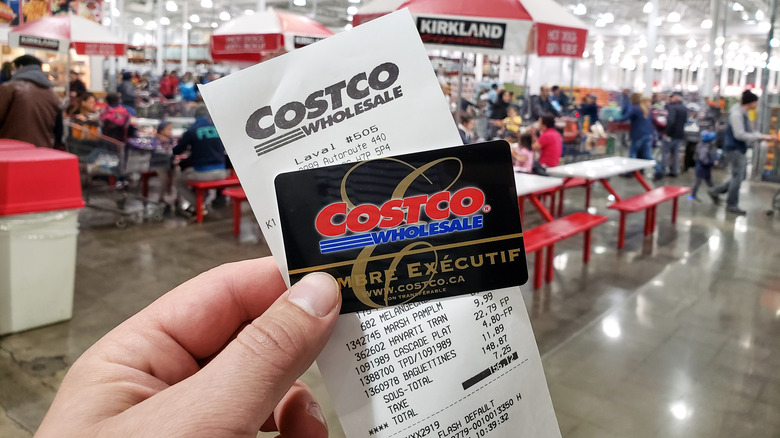 a person holding up a costco card