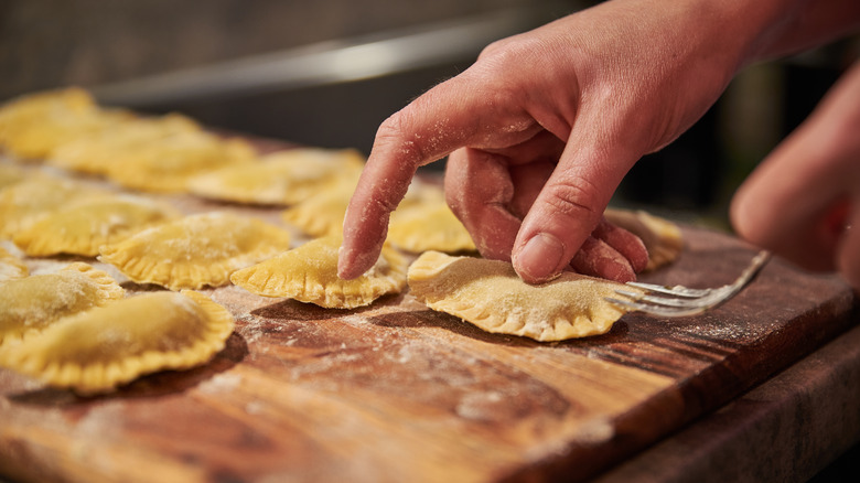 Raviolis being made on brown wood