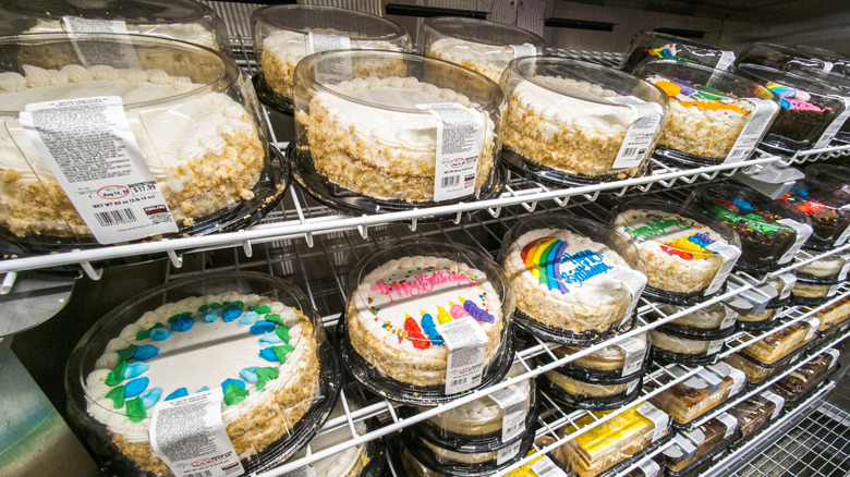 Selection of refrigerated Costco cakes on wire rack shelves