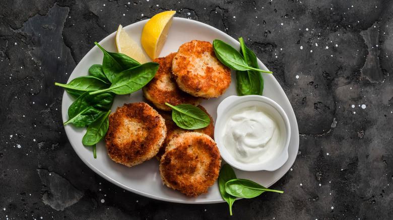 fried breaded salmon cakes with sauce and lemon
