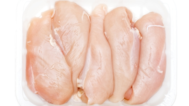 Five raw chicken breasts in plastic packaging