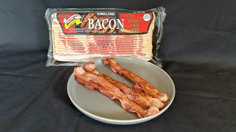 Kirkland low sodium bacon package behind plate of cooked bacon