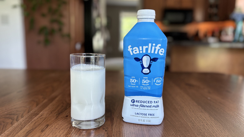 Glass of milk next to a Fairlife bottle