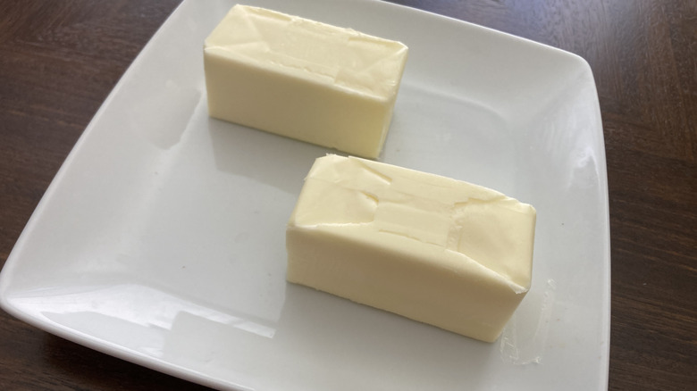 sticks of unwrapped butter on plate