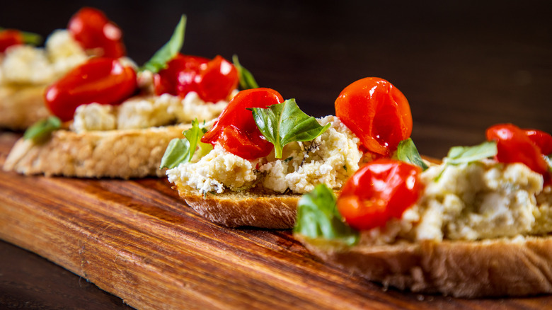 baguette slices topped with goat cheese and tomato and basil