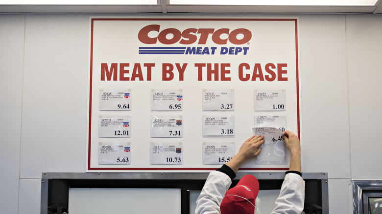 Costco Employee changing sign in meat department