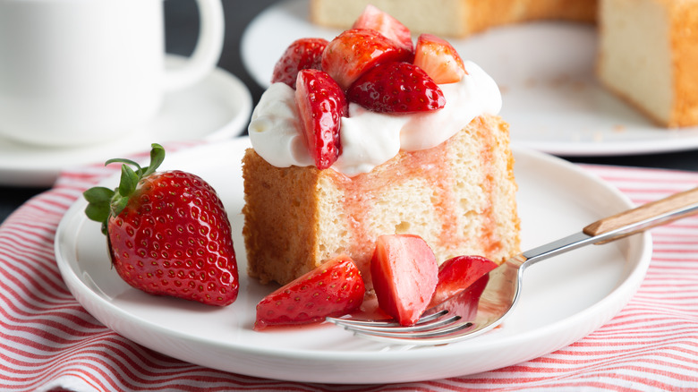 White cake with whipped cream and fresh strawberries
