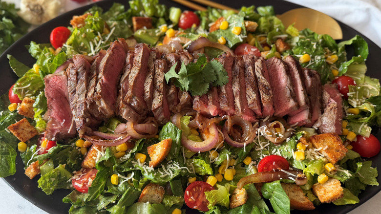 Cowboy Caesar salad topped with sliced steak