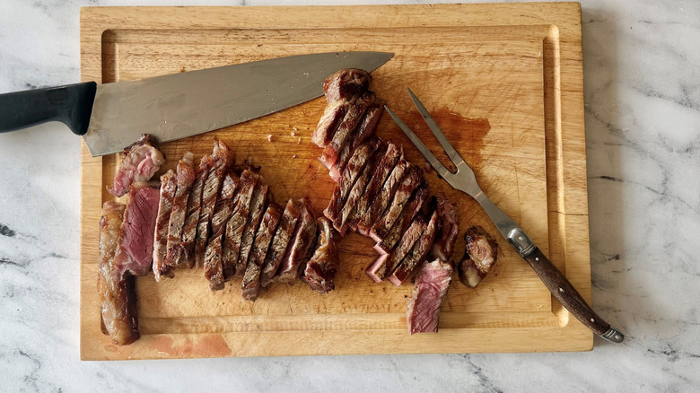 Sliced steak on wooden board
