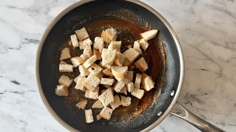 Cubed bread in pan with seasoned butter