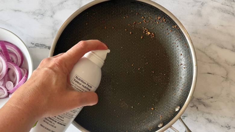 Hand spraying pan with cooking spray
