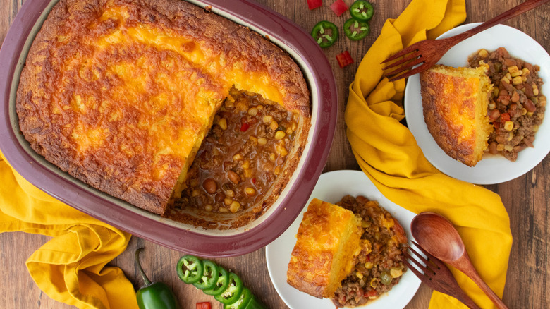 Cowboy cornbread casserole in dish next to servings on plates