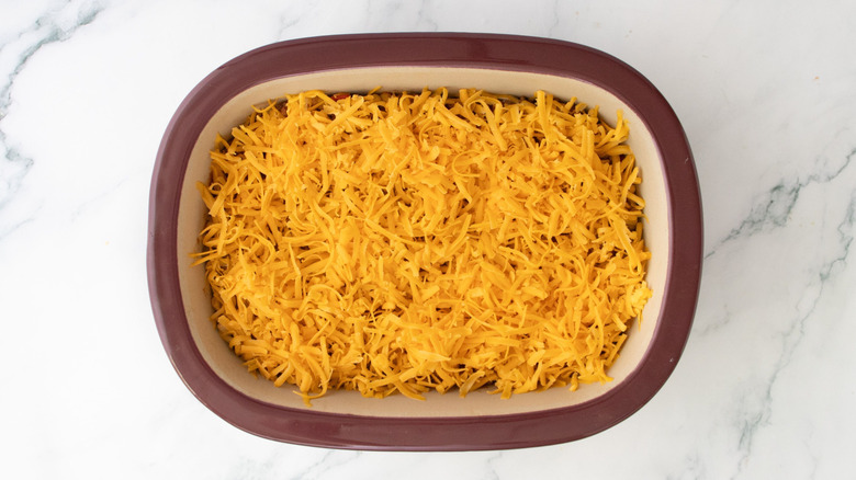 Shredded cheddar cheese in casserole dish