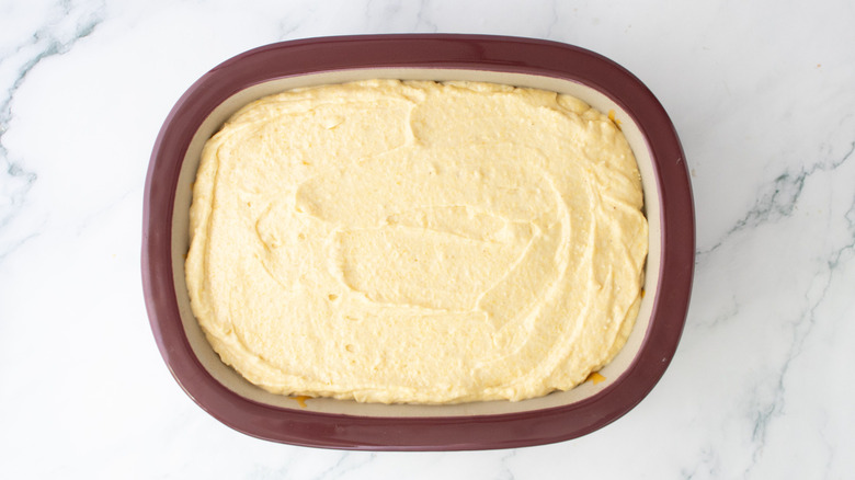 Cornbread batter spread out in casserole dish