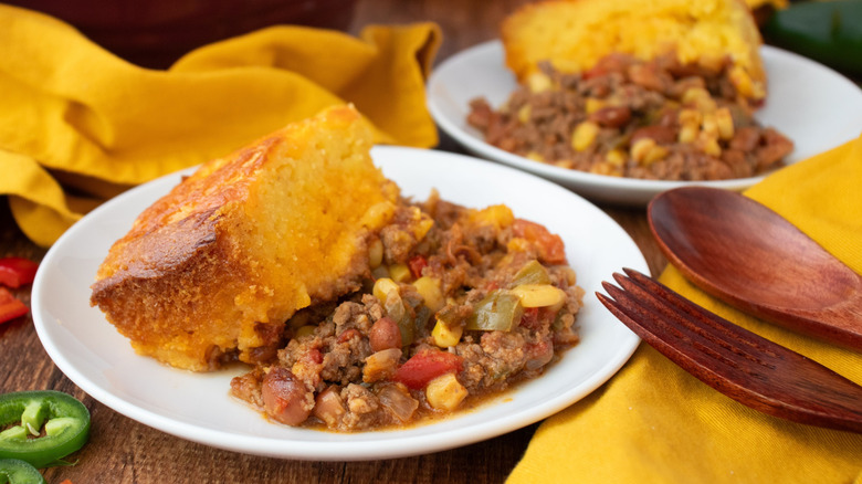Casserole servings with cornbread on plates