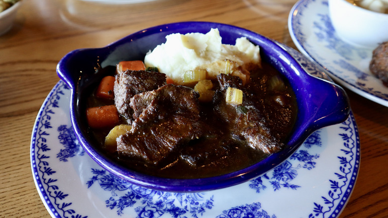 pot roast with carrots and potatoes in blue bowl