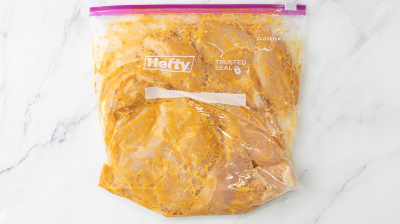 Raw chicken marinating in plastic bag