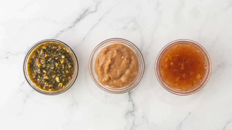 Three sauces in small bowls on countertop