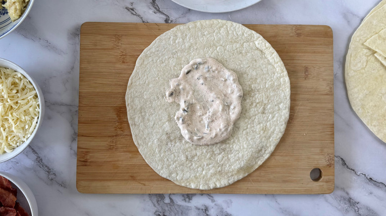 flour tortilla with sauce in the middle on a cutting board