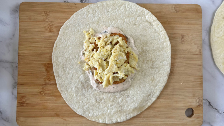 flour tortilla with scrambled eggs on a cutting board