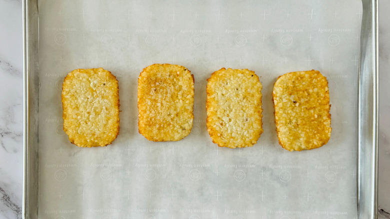 frozen hash browns arranged on a lined baking pan