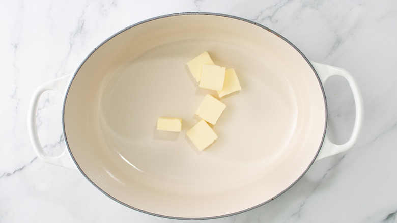 butter chunks in a white casserole dish