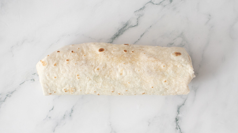 rolled flour tortilla on a countertop