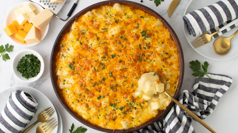 cheese-topped potato casserole in a round pan