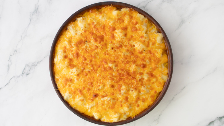cheese-topped potato casserole in a round pan