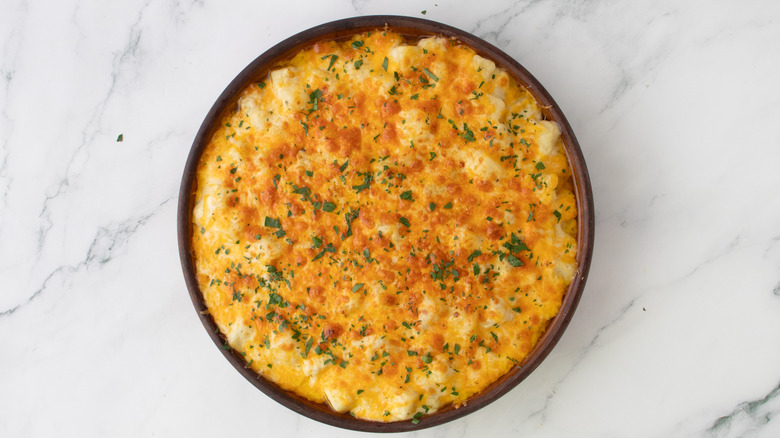 cheese-topped potato casserole in a round pan