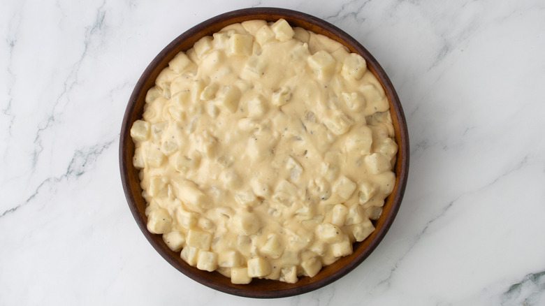 potatoes and cheese sauce in a round pan