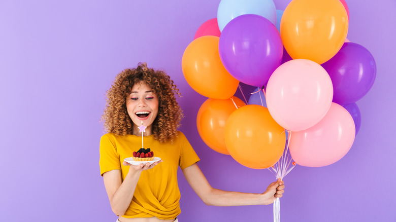 woman holding birthday dessert