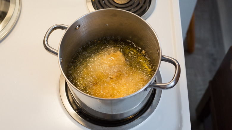 fish frying in medium pot