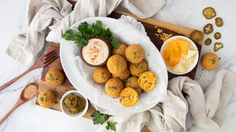 fried cheese balls on a white plate with a white dip
