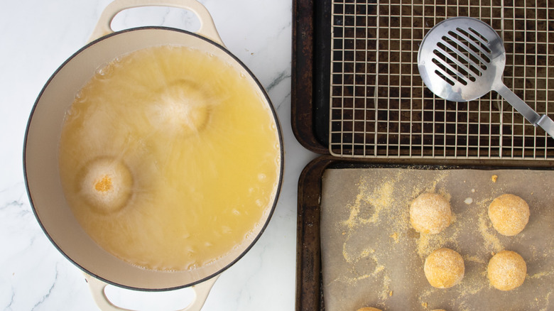 cheese balls frying in a white pot
