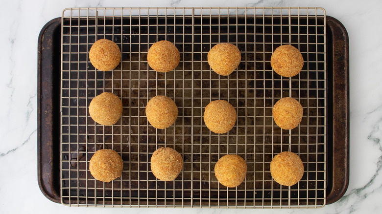 fried cheese balls on a wire rack over a baking pan