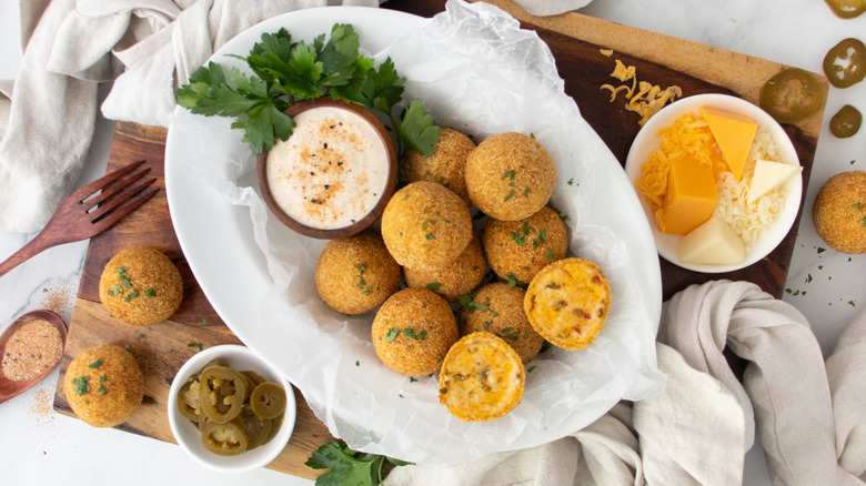 fried cheese balls on a white plate with a white dip