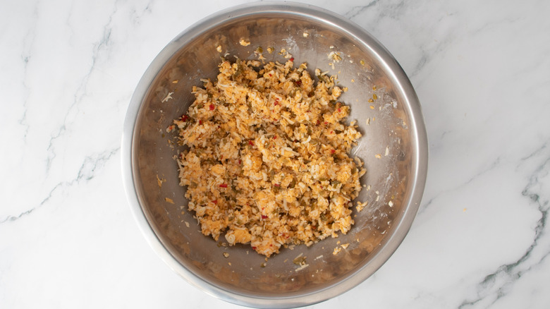 shredded cheese and chopped peppers in a metal bowl