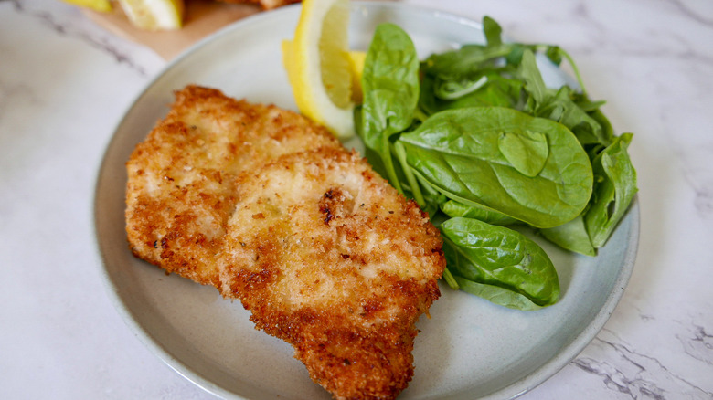 crispy chicken on a plate with greens