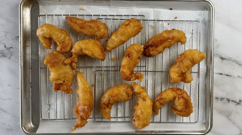 12 battered chicken strips on a wire rack