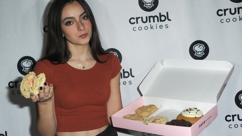 woman holding crumbl cookies