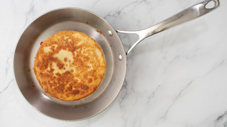 whole toasted quesadilla in silver-colored frying pan