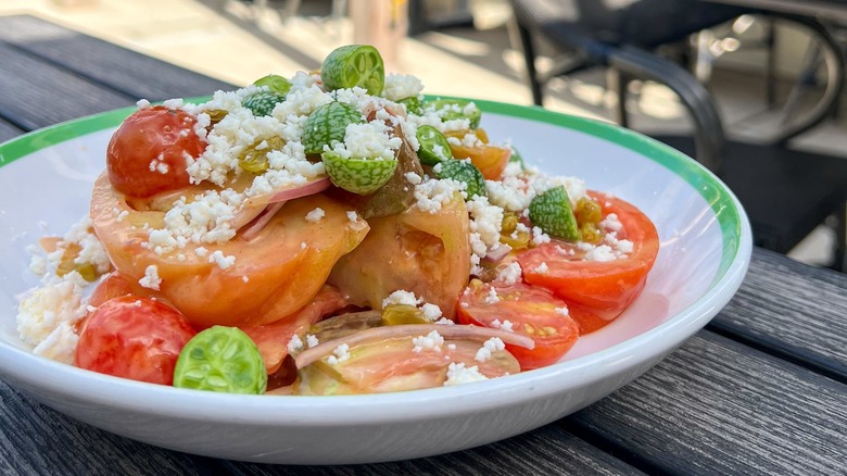 Tomato and feta salad topped with cucamelons