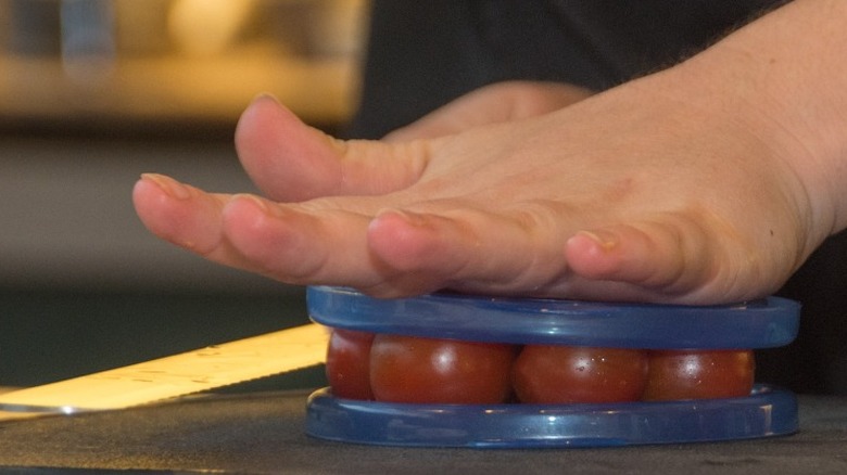   Kirschtomaten zwischen Platten mit Messer