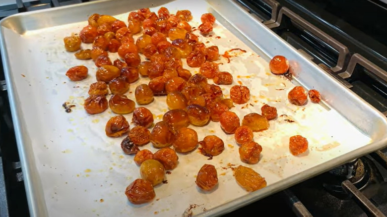  tomates cherry asados ​​en una bandeja para hornear en el horno
