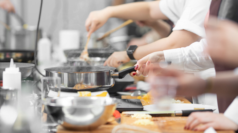 Line of student chefs in action