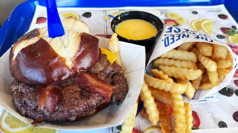 Culver's Pretzel Haus Pub Burger with cheese dipping sauce and fries on a tray