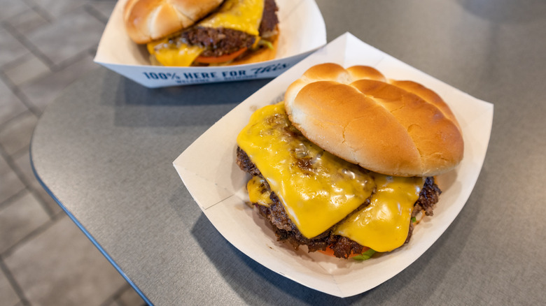 Two Culver's ButterBurgers on table inside restaurant.