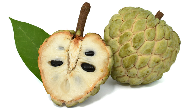 Two custard apples, one cut in half.